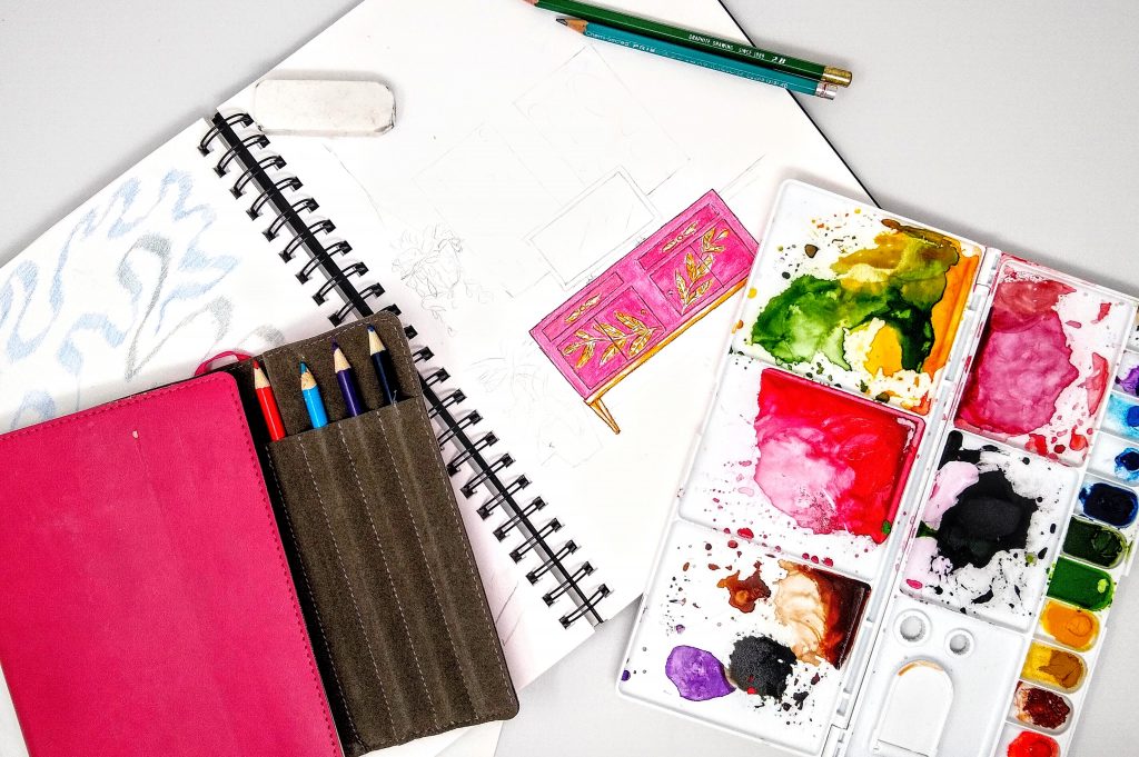 Inside sketchbook, paint pallette, and travel sketchbook